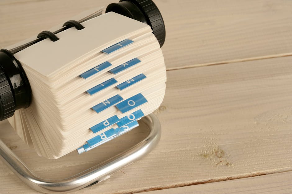 pexels-photo-12585541-12585541 A close-up of a traditional Rolodex with alphabet tabs on a wooden desk.