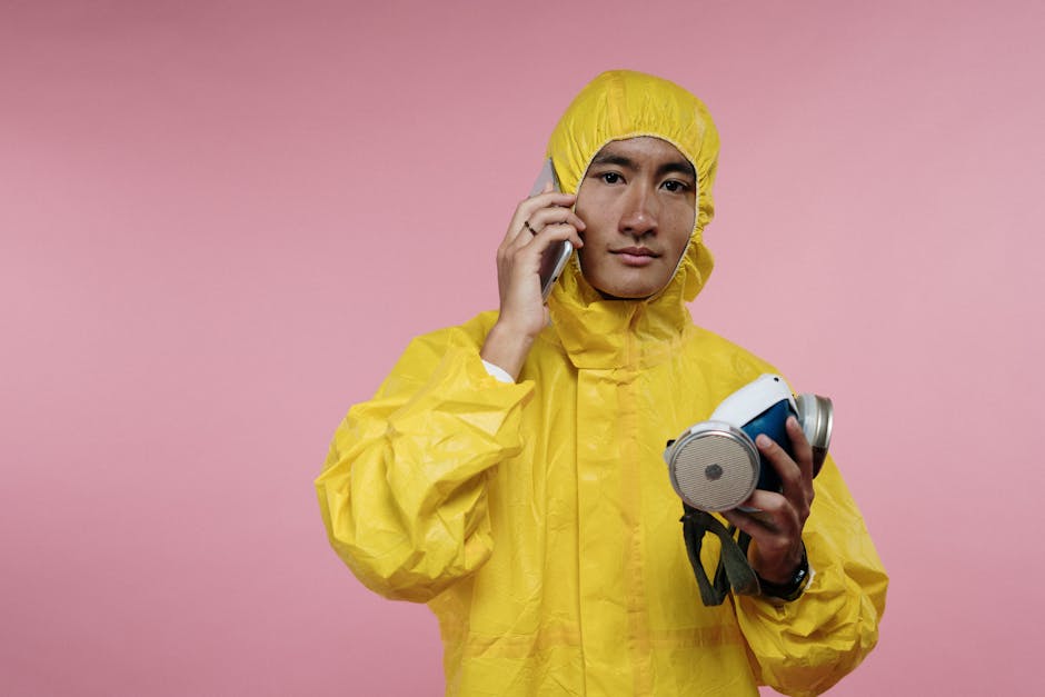 Individual in a yellow hazmat suit making a phone call, emphasizing safety and communication.